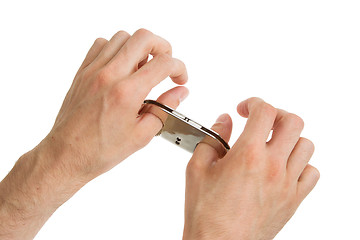 Image showing Adult hands in thumb cuffs isolated