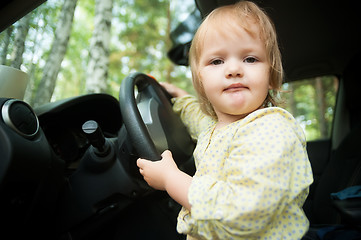 Image showing Little blond girl driving car