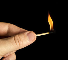 Image showing Hand holding burning match stick