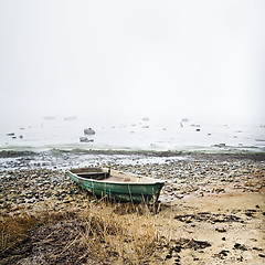 Image showing Old fishing boat at coast foggy in the morning