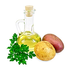 Image showing Potatoes red and yellow  with a bottle of oil