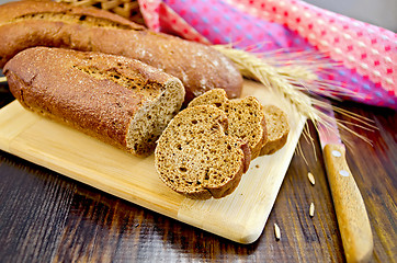 Image showing Rye baguettes with a knife and a wicker basket