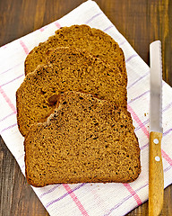 Image showing Rye bread slices with a knife on a napkin