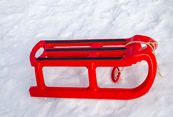 Image showing plastic red sleigh with black rim yard in winter  