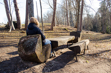 Image showing blond woman sit wooden chair warm spring sun park 