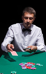 Image showing Gentleman in white shirt, playing cards