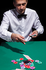 Image showing Gentleman in white shirt, playing cards