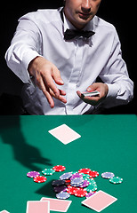 Image showing Gentleman in white shirt, playing cards