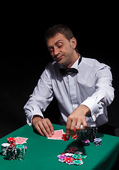 Image showing Gentleman in white shirt, playing cards