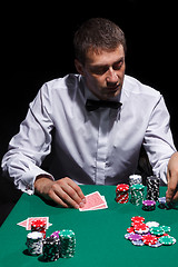 Image showing Gentleman in white shirt, playing cards