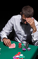 Image showing Gentleman in white shirt, playing cards
