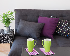 Image showing Sofa with bright cushions and green cups on a table