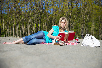 Image showing Young Woman Reading Book On Beach