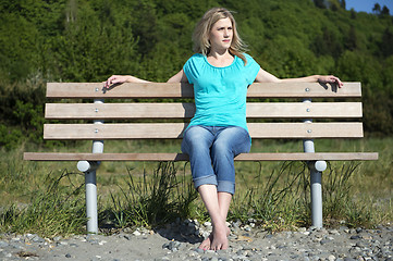 Image showing Young Woman Sitting On Bench At Beach