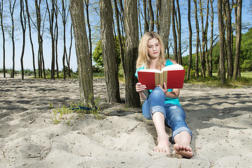 Image showing Young Woman Reading Book On Beach