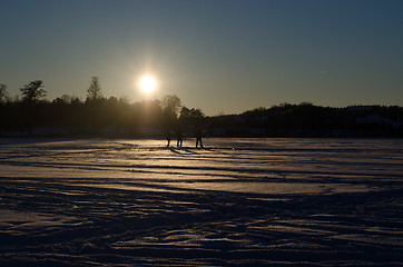 Image showing people silhouette  frozen lake snow sunset evening 