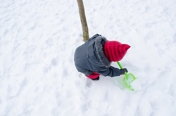 Image showing girl with red hat shovel dig snow 