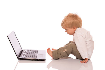 Image showing Young boy looking at a laptop