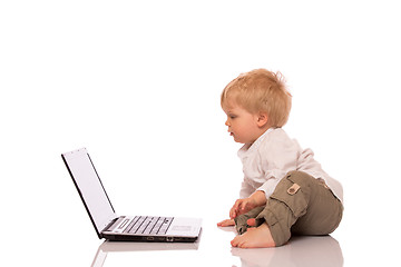 Image showing Young boy looking at a laptop