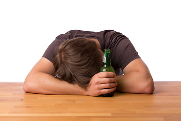 Image showing Man sleeping on a table with beer