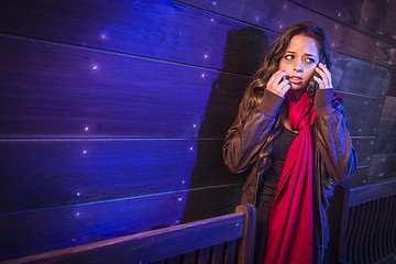 Image showing Frightened Young Woman in Dark Walkway Using Cell Phone