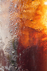 Image showing Fizzy cola in a glass with ice cubes