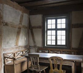 Image showing rustic chamber with bench, table and chair.