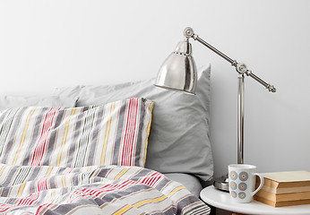 Image showing Lamp and books on a side table near bed