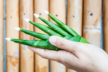 Image showing Hand hold a part of banana leaf rice offering