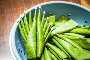 Image showing Handmade banana leaf rice offering on wood table