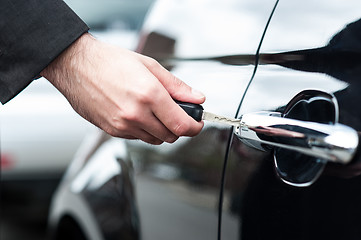 Image showing Man inserting car key into the door lock