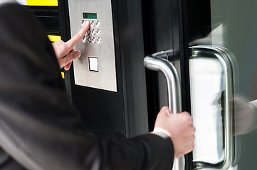 Image showing Man entering security code to unlock the door