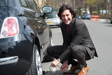 Image showing Businessman repairing car roadside