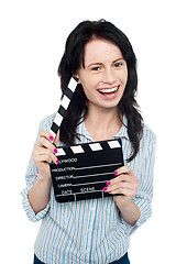 Image showing Young charming girl holding clapperboard