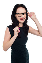 Image showing Charming smiling lady adjusting her eyeglasses