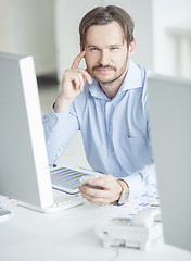 Image showing Businessman sitting in front of computer monitors