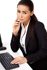 Image showing Woman in black suit sitting in front of computer