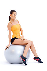 Image showing Athletic woman relaxing on fitness ball