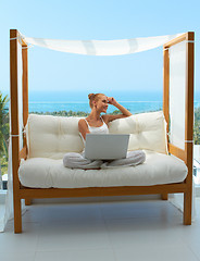 Image showing Woman with laptop on canopied seat