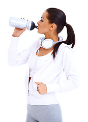Image showing Sporty woman drinks from fitness bottle