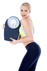 Image showing Smiling woman holding a waight scale