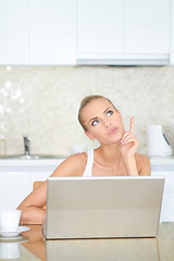 Image showing Thinking woman sitting at laptop computer