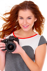 Image showing Woman in gray dress wit digital camera on white