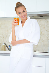 Image showing Woman enjoying fresh orange juice for breakfast