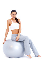 Image showing Athletic woman relaxing on fitness ball