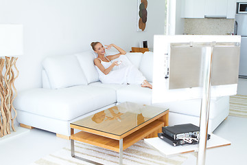 Image showing Beautiful woman watching tv in home indoor