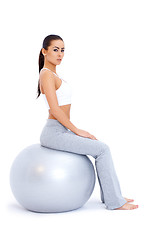 Image showing Athletic woman relaxing on fitness ball