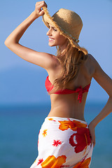 Image showing Smiling blonde with hat for sun protection