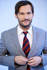 Image showing Smiling businessman buttoning his jacket