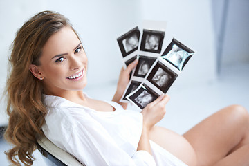 Image showing Pregnant woman holding her USG pictures